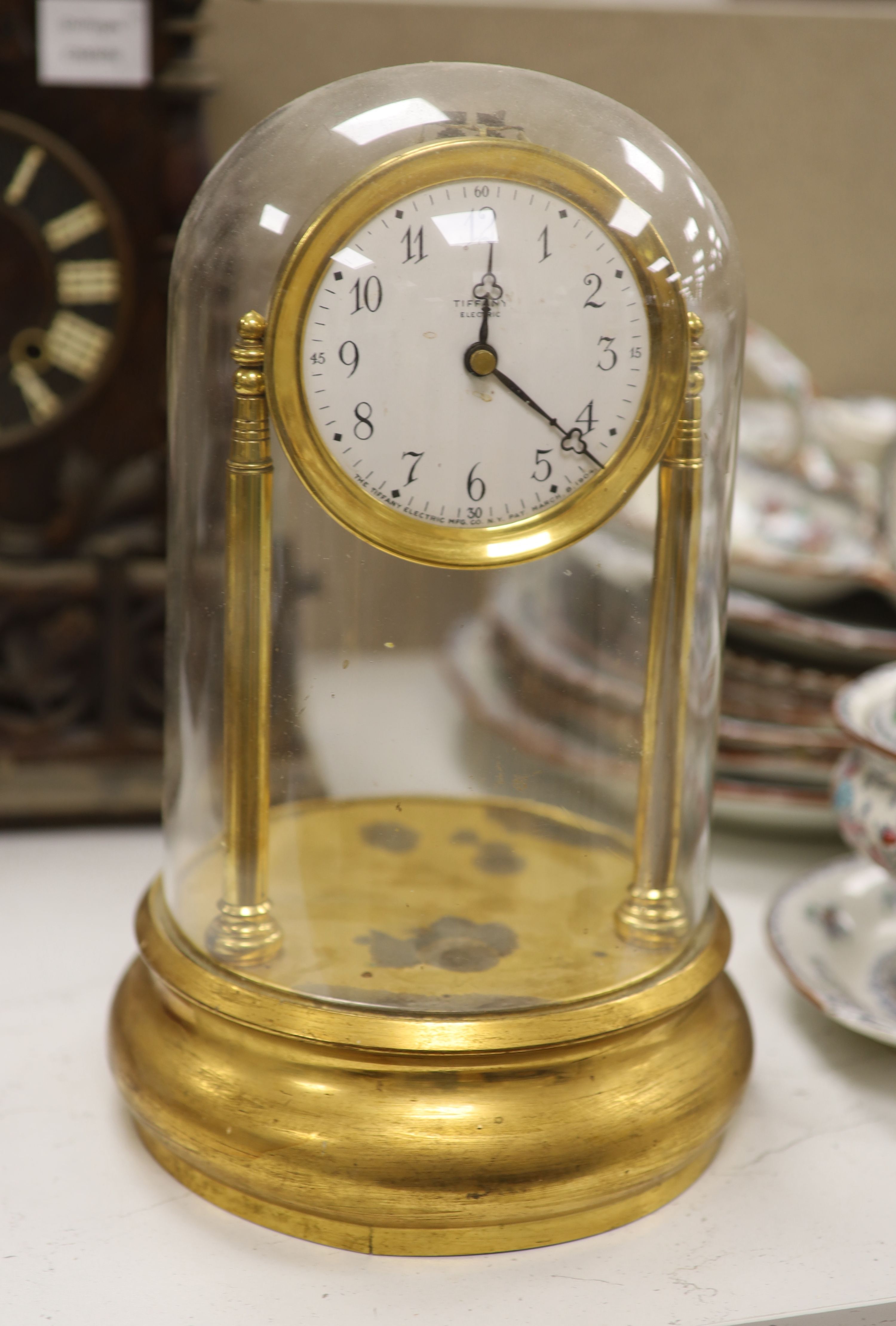 A Tiffany brass never wind electric clock, under glass dome, overall height 32cm